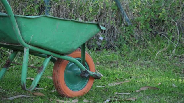gardener pushing a wheelbarrow slow motion
