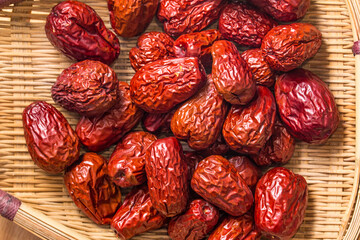 The bamboo dustpan is filled with bright red Xinjiang dates
