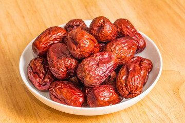 The bamboo dustpan is filled with bright red Xinjiang dates