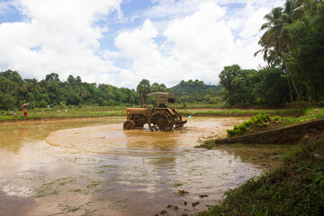 Fototapeta premium Tractor preparing land with seedbed cultivator as part of pre seeding activities in early spring season of agricultural works at farmlands.