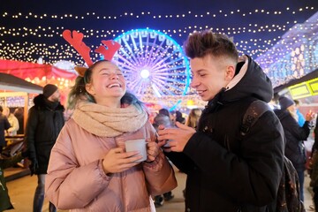 Young people, couple of teenagers having fun at Christmas market