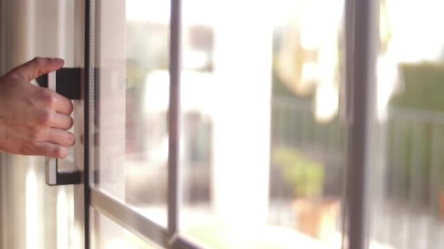 young man opening balcony sliding window door slow motion