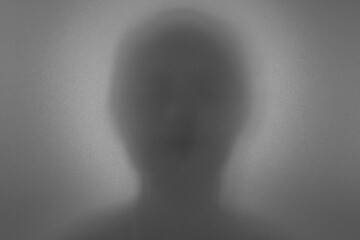 Dummy Image. Blurry dark silhouette of a woman figure behind a smoked glass.	