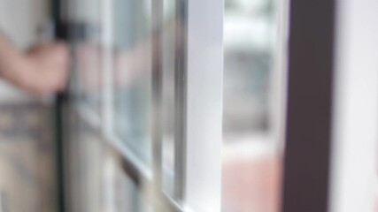 young man closing balcony sliding window door slow motion