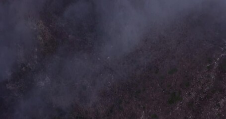 Fog and clouds cover a mountain terrain. Shot from above in 4k ariel by drone. Great for scary events, holloween, or anythng related to the mountains or mother nature