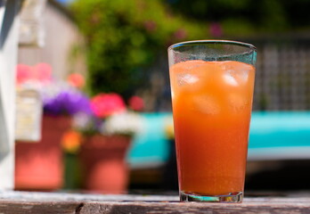 orange drink by colorful flowers