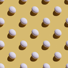 Trendly sunlight food pattern made with whole eggs on yellow background. Minimal food concept.