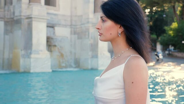 close up on beautiful elegant woman walking around the janiculum fountain