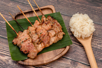 Thai traditional grilled pork and steamed sticky rice on wooden background 