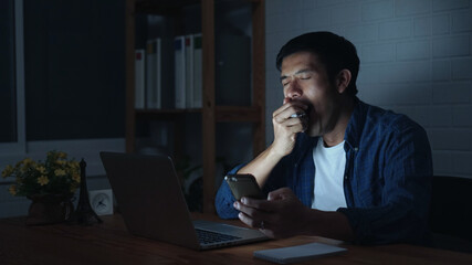 Man working at night falling asleep at workplace, tired overworked deprived worker sleepy employee gaping suffering from lack of sleep, feeling bored or chronic fatigue in office concept, side view