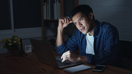 young man work hard on modern loft office at night. Man using laptop computer,