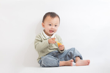 A cute two-year-old boy eats cookies