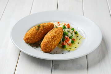 Cutlet stuffed with cheese served with rice, green pea and carrot