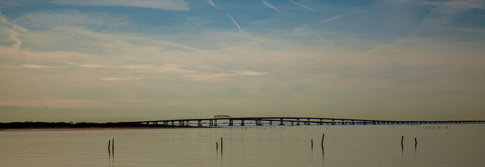 A sunset panorama featuring the silhouette of  Lucius J. Kellam Jr. Bridge tunnel, better known as the Chesapeake bay bridge tunnel. It is among world's longest and tallest bridges