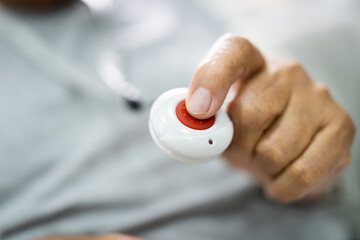 Close-up Of Senior Man Pressing Alarm Button