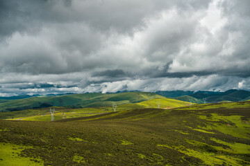 Fototapeta premium The green meadows on mountains in Tibet, China, summer time, on a cloudy day.