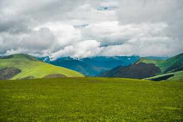Fototapeta premium The green meadows on mountains in Tibet, China, summer time, on a cloudy day.