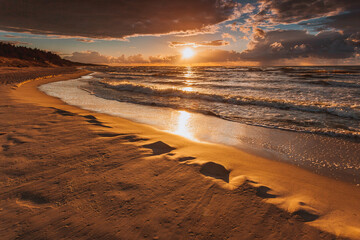 Beatiful sunset with clouds over sea and beach