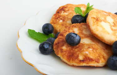 cottage cheese pancakes on a plate with blueberries and mint