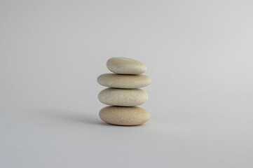 Fototapeta na wymiar One simplicity stones cairn isolated on white background, group of four white pebbles in tower