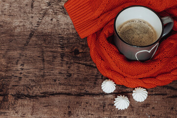  Cup of coffee on a wooden background with a cozy knitted sweater. Free space for text
