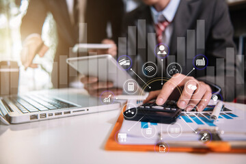 Teamwork process, Business team using a calculator to calculate the numbers of statistic business profits growth rate on documents graph data, desk in a office.