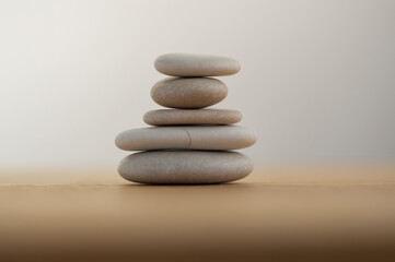 Stone cairn on striped grey white background, five stones tower, simple poise stones, simplicity harmony and balance,