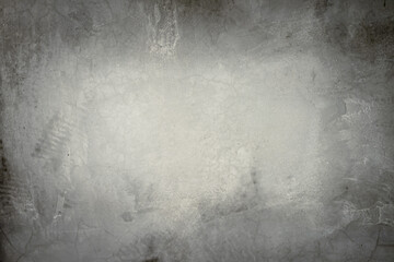 Image of cement wall old gray grunge with a rough texture and different decorative patterns. There are vignettes and the center of the image is bright. The idea for vintage background with copy space.