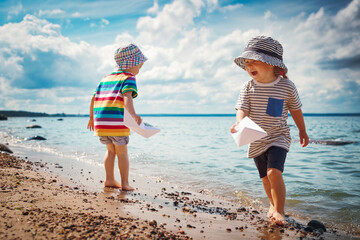 Babygirl and babyboy sitting on the beach