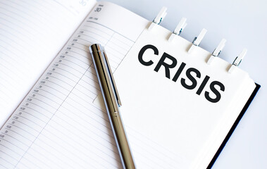 text CRISIS on the short note texture background with pen