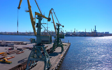 Aerial view of a row of construction or cargo cranes on the river bank.