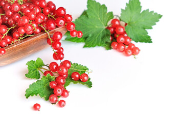 fresh red currant in a wooden bowl isolated on white background. summer harvest of vitamins.