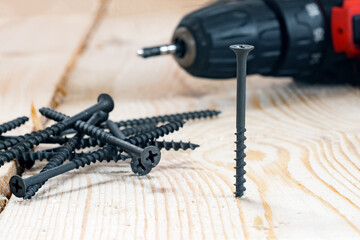 Wood screw close-up on the background of an electric screwdriver