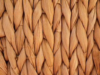 Twisted straw background from aquatic hyacinth, close up. Traditional handcraft weave Thai style pattern. Palm fiber place mat. Wicker or rattan basket texture.