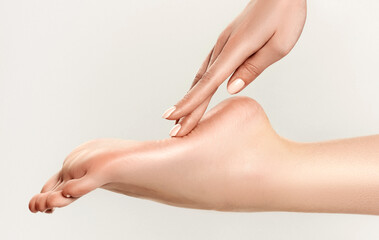 Perfect clean female foot . Beautiful and elegant groomed girl's hand touches her feet . Spa ,scrub...