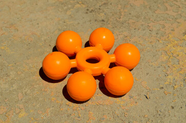 a round plastic toy in the form of an atom lies on the concrete surface