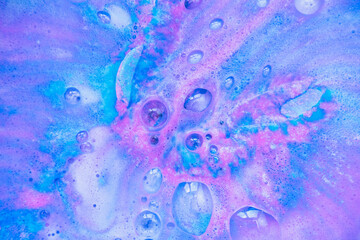 Beautiful bath bomb dissolves in blue and pink colors in the water. - 368600824