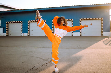 African American girl - dancer dancing in the street at sunset. Sport, dancing and urban culture concept. Fashion lifestyle.