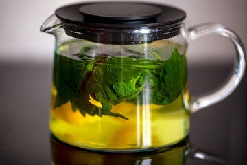 Mint and lemon brewing in glass teapot