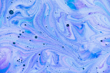Bath bomb dissolves in blue, purple and pink colors in the water. Flat lay, top view, directly above. - 368601255