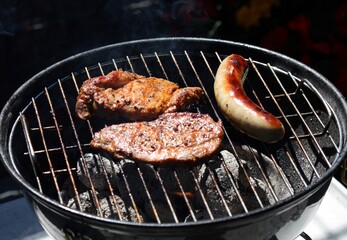 Bratwurst und Steak auf dem Holzkohlegrill

