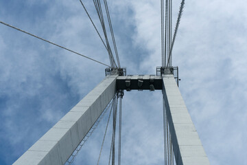 Pillars of the suspension bridge against the cloudy sky.