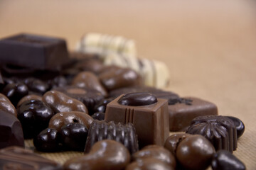 Chocolate pralines on a brown background stock images. Chocolate pralines on a brown background with copy space for text stock images. Various chocolate candies frame. Pile of different chocolates