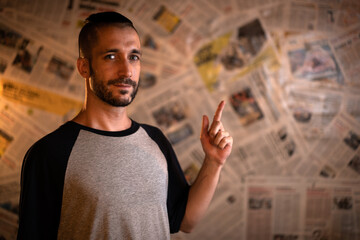 Hombre con peinado moderno y ojos azules, y camiseta gris de mangas azul marino, mirando a cámara...