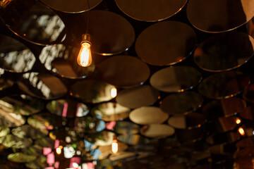 Stylish abstract bar interior. The ceiling is decorated with small round mirrors.