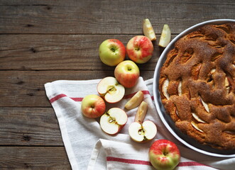 Round apple pie or biscuit on a white napkin with fresh pears on a wooden table.