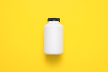 White plastic jars on the yellow flat lay background.