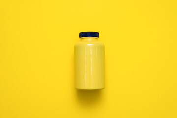 Yellow plastic jar on the yellow flat lay background.