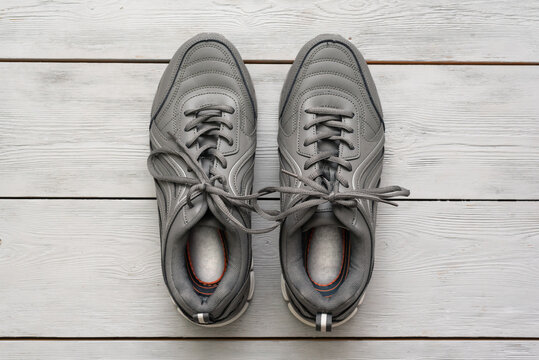 Gray sport shoes on the wooden floor background.