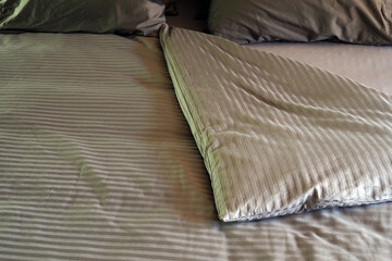 A blanket, pillows and bedding in a spread double bed.